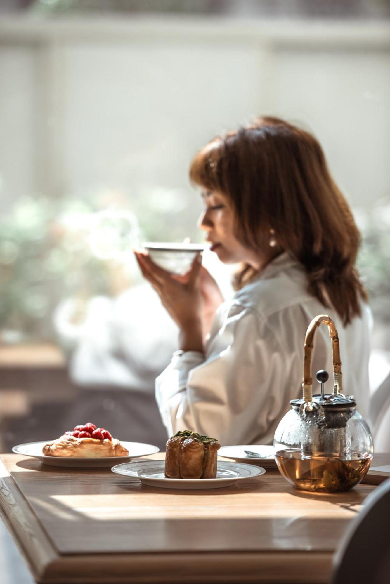 Dusit Doha Hotel Εξωτερικό φωτογραφία A woman drinking tea